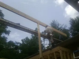Carpenter setting a ridge beam over a new addition frame — Ice Dam Removal by Roofing Brothers in Seagrove