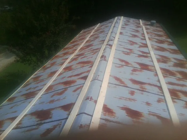 Rusted metal roof panels with new wood purlins before replacement — Storm Damage Roof Repair in Seagrove by Roofing Brothers