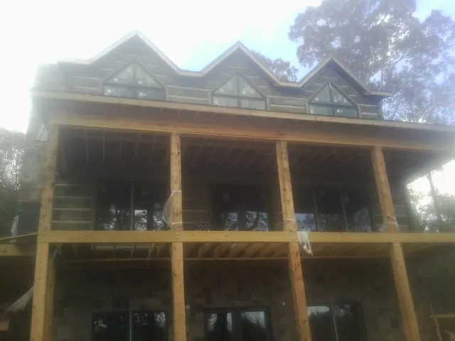Dormers and porch framing on a large log home under construction — Roof Coating work by our crew in Seagrove