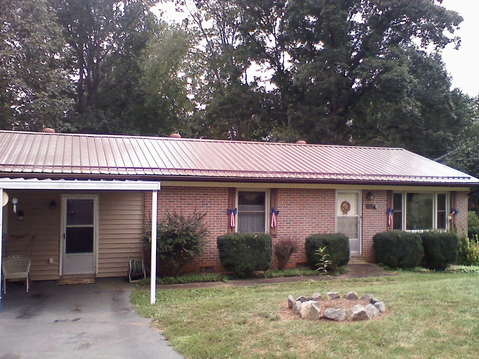 Bronze metal roof and carport on a brick ranch home — Roof Repair work by our crew in Seagrove