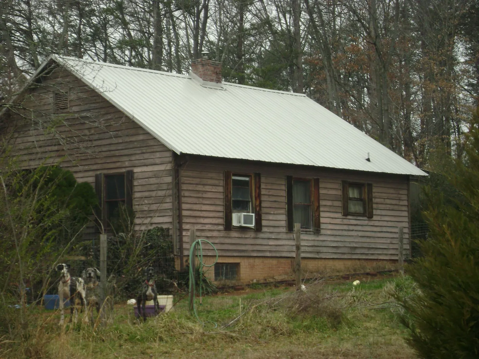 White metal roof on an old wood sided farmhouse, from a Metal Roof Installation job in Seagrove